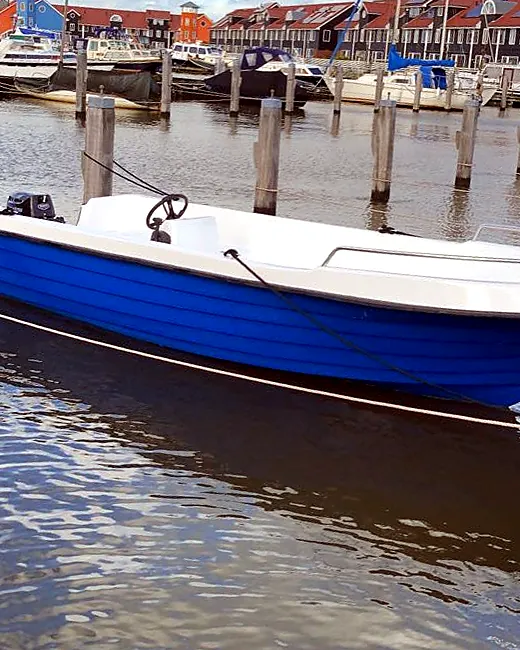De gerestaureerde blauwe sloep afgemeerd in een jachthaven